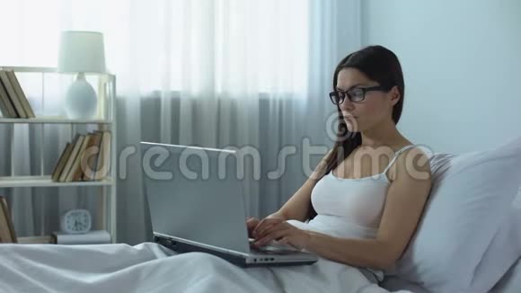 工作过度的女士在床上用笔记本电脑打字工作压力大工作不停视频的预览图