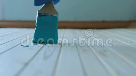 油漆工沿着一个干净的木板用绿松石油漆缓慢地运动选择性聚焦特写视频的预览图