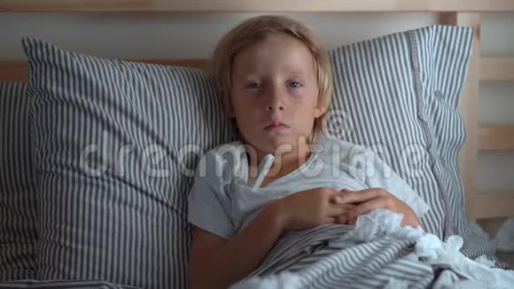 一个生病的小男孩躺在床上妈妈测量他的体温婴儿流感概念视频的预览图