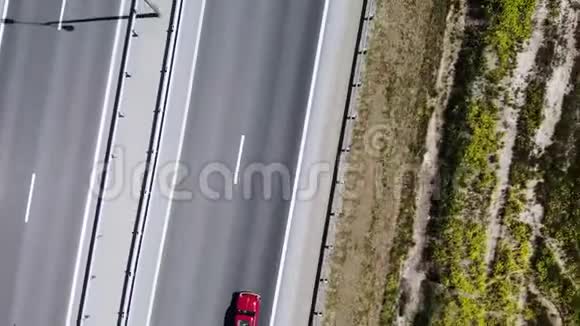 一辆红色复古汽车在道路或高速公路上行驶的空中景色高速公路上的车不多视频的预览图