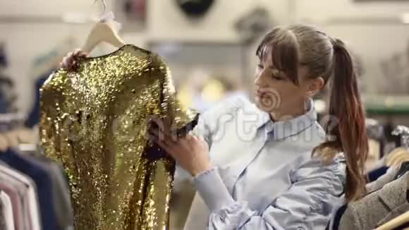 成年白种人幸福的女人在服装店里展示着金色的火花视频的预览图