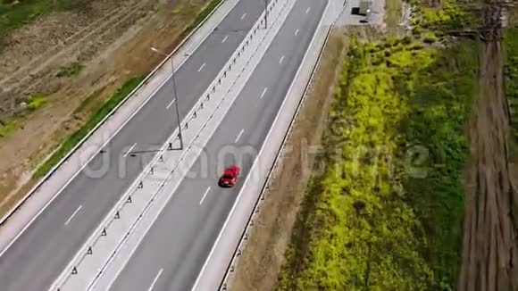一辆红色复古汽车在道路或高速公路上行驶的空中景色高速公路上的车不多视频的预览图
