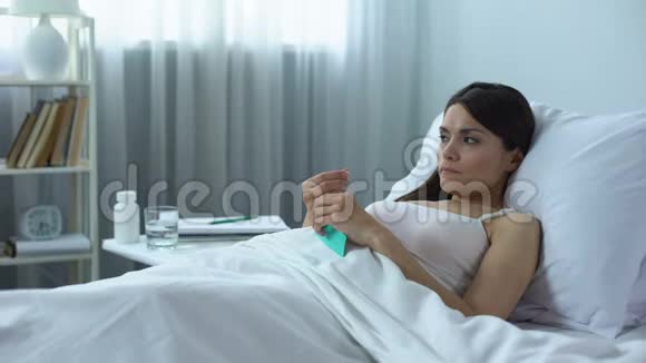 伤心沮丧的女人躺在床上服用强力药丸化疗过程视频的预览图