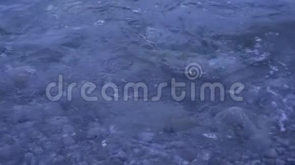 波浪在岸上的石头和鹅卵石上洗涤慢动作视频的预览图