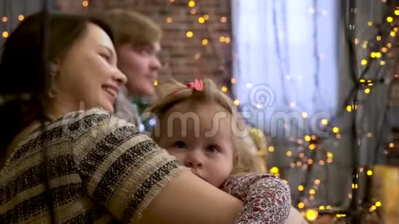 快乐的家庭妈妈和小女儿在冬天玩圣诞假期闪闪发光的背景视频的预览图