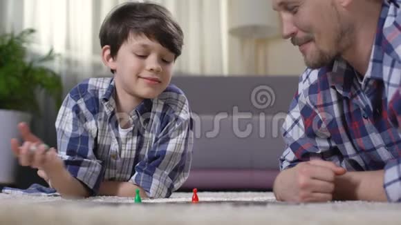 父亲和儿子玩刺激的棋盘游戏父母培养男孩的技能视频的预览图
