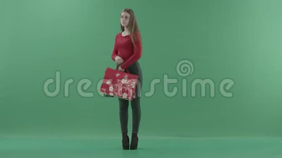 美丽快乐的女人穿着休闲服摆着购物袋她站在一间工作室里反对视频的预览图