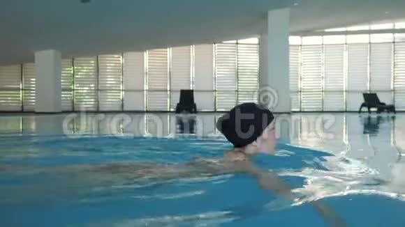 年轻女子在游泳池里自由泳侧视视频的预览图