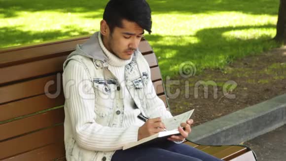 年轻人在笔记本上写东西视频的预览图