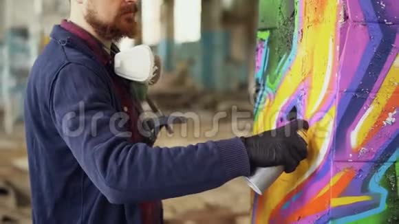 胡子男涂鸦画家正在用气溶胶涂料装饰旧工业建筑中的柱子现代都市艺术视频的预览图