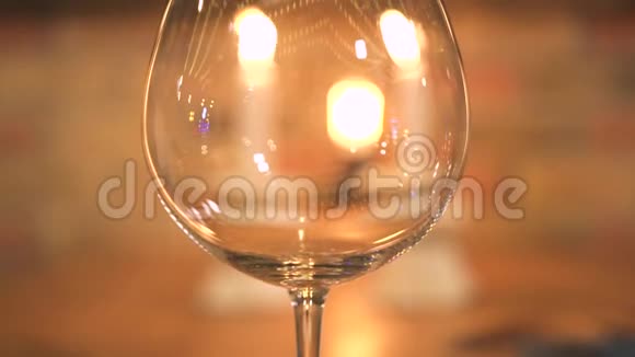在燃烧的蜡烛背景上倒空酒杯用蜡烛把酒杯放在晚宴桌上视频的预览图