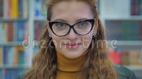 城市大学图书馆眼镜阅读中的年轻漂亮女子微笑少女画像视频的预览图