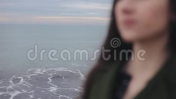 模糊的女性颈肩特写那个穿着深绿色外套的女孩在海边焦点转移到视频的预览图
