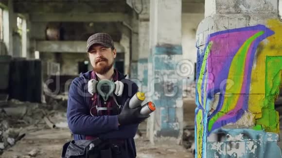 留胡子的涂鸦画家站在旧的空楼里背景是涂鸦画手持涂鸦画视频的预览图