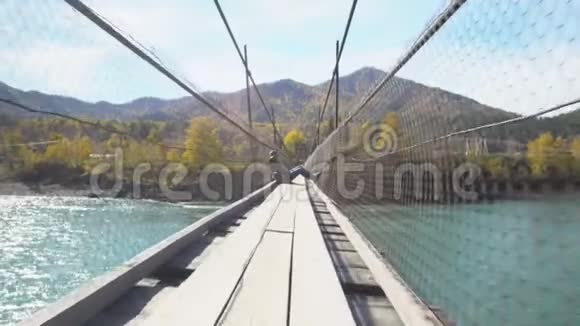 穿山河的吊桥上的女旅行者河的景色视频的预览图