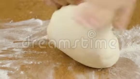 男人或女人的厨师他的手揉着棕色桌子上的披萨面团特写选择性聚焦4K视频视频的预览图