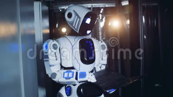 类似人类的机器人站在服务器机房里手提电脑视频的预览图