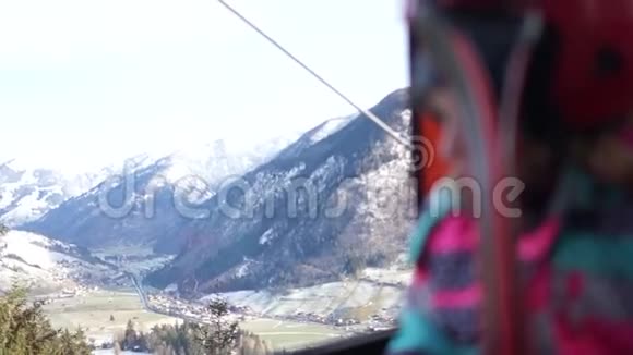 一个穿着滑雪装备和头盔的女孩的肖像少年站在滑雪缆车舱里焦点从视频的预览图