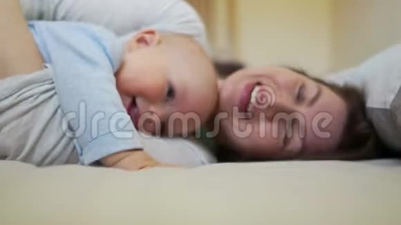 早上在床上拥抱和亲吻妈妈和宝宝母亲节视频的预览图