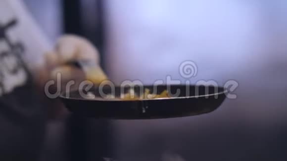 厨师在乳胶手套准备炒鸡蛋在黑色煎锅上的炊具视频的预览图