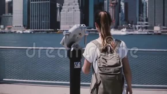 年轻的旅行者女孩通过硬币双目望远镜观察惊人的城市天际线曼哈顿纽约慢动作视频的预览图