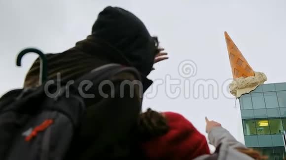 孩子把她的父亲指着德国科隆屋顶上标志性的巨型冰淇淋视频的预览图