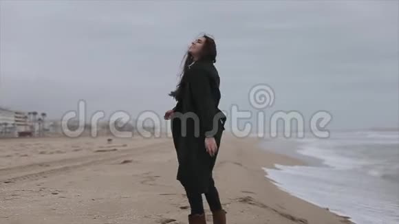 秋天的一天一个美丽快乐的年轻女孩在海边享受自由慢动作视频的预览图