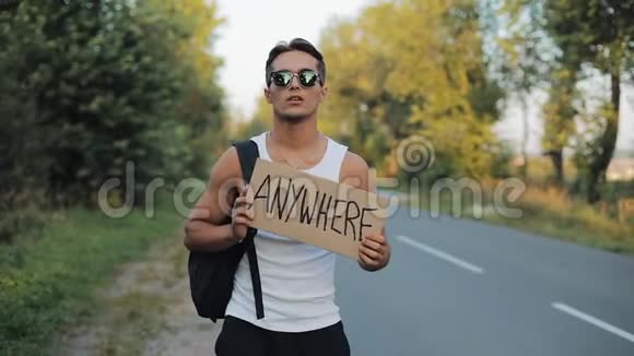 一个旅游搭便车的人走在路上肩上背着一个背包在任何地方签名旅行者试图阻止视频的预览图