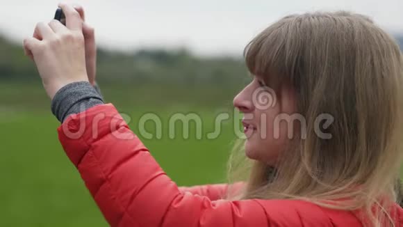 年轻女子为爱尔兰典型的绿色景观拍照视频的预览图