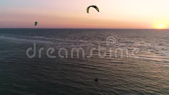空中拍摄海上日落几个人在海上进行风筝冲浪视频的预览图