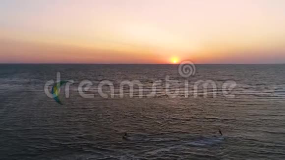 一对风筝爱好者在日落时分在海里游泳空中射击视频的预览图