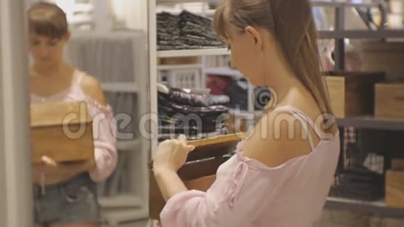 家庭商店里漂亮的女人年轻的白种人女性打开木箱在镜子前惊喜视频的预览图