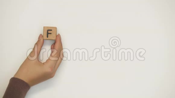 母亲和孩子用手在木立方体上做的家庭字捧着心视频的预览图