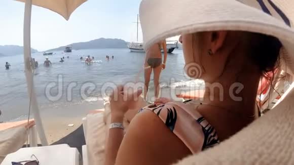 特写4k视频优雅的年轻女子在海边与鸡尾酒放松视频的预览图