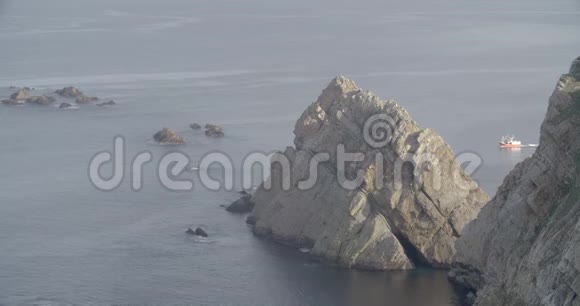 一艘船在右侧航行在海附近形成一个巨大的岩石群视频的预览图