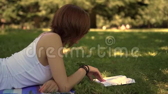 躺在公园草地上看书的女孩视频的预览图
