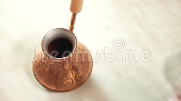 将水倒入传统的土耳其铜咖啡壶中视频的预览图