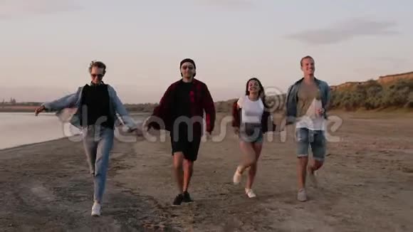 年轻人沿着海边奔跑的完整镜头年轻女孩转身试图向后跑友谊视频的预览图