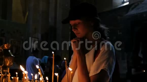 女游客在一座正统天主教古寺祈祷视频的预览图