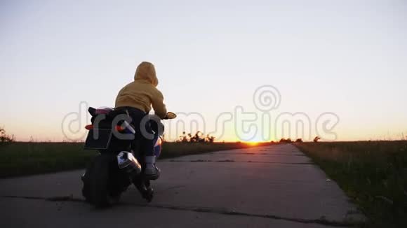 一个三岁的男孩骑着玩具摩托车上路视频的预览图