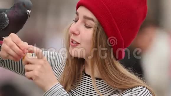 在户外喂鸽子的年轻女子视频的预览图