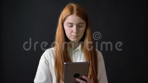生姜迷人的女人在平板电脑上打字并在相机中显示带有色度的显示器在黑色背景上隔离视频的预览图