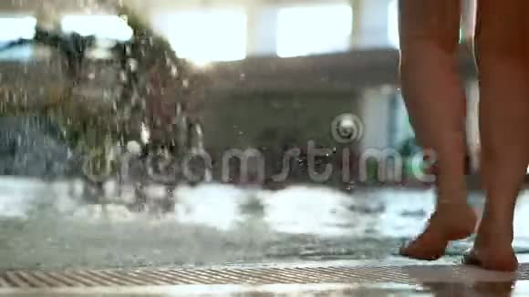 公共水上公园的游泳池从喷泉里溅出水花女性的腿视频的预览图