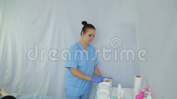 一位美容师女士准备了一个糖膏来做一个剃须视频的预览图