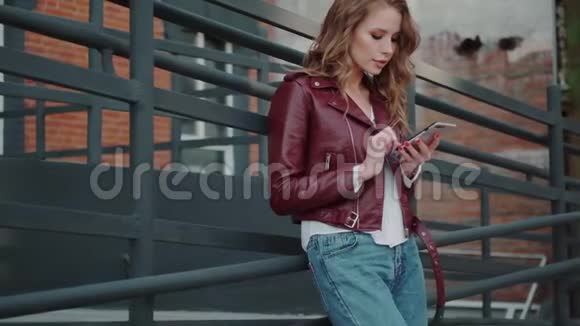 时尚的年轻女性在户外使用手机视频的预览图