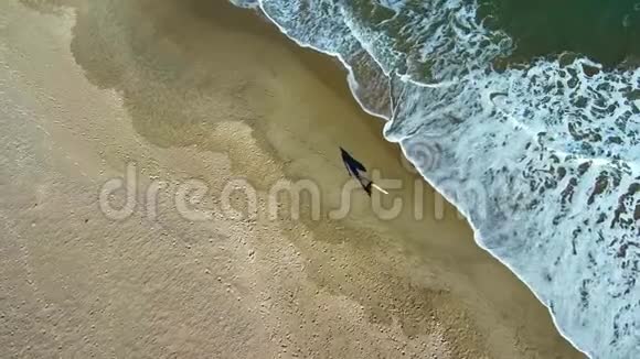 海滩上冲浪者散步的鸟瞰图视频的预览图