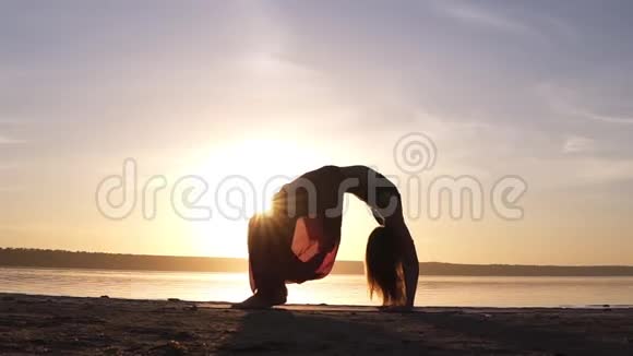 年轻女子穿着漂亮的彩色瑜伽裤正在做瑜伽运动也被称为向上鞠躬姿势视频的预览图