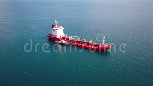 红色油轮船在水上的鸟瞰图拖船靠近港口视频的预览图