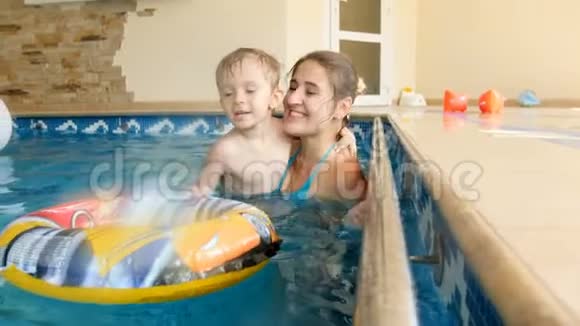 4k视频可爱的微笑幼儿男孩与母亲在游泳池游泳一只狗视频的预览图