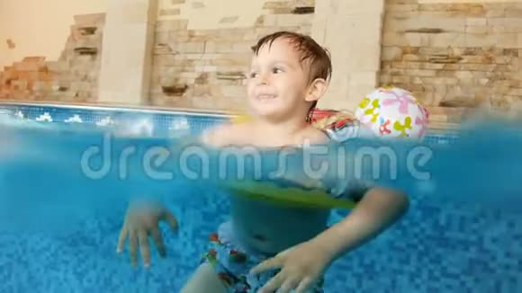 4k视频快乐微笑幼儿男孩在充气环游泳在室内游泳池在酒店视频的预览图